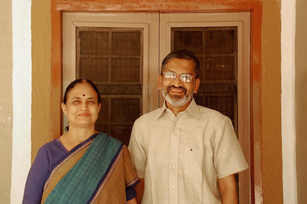 Rani Bang and Abhay Bang standing side by side in a doorway.