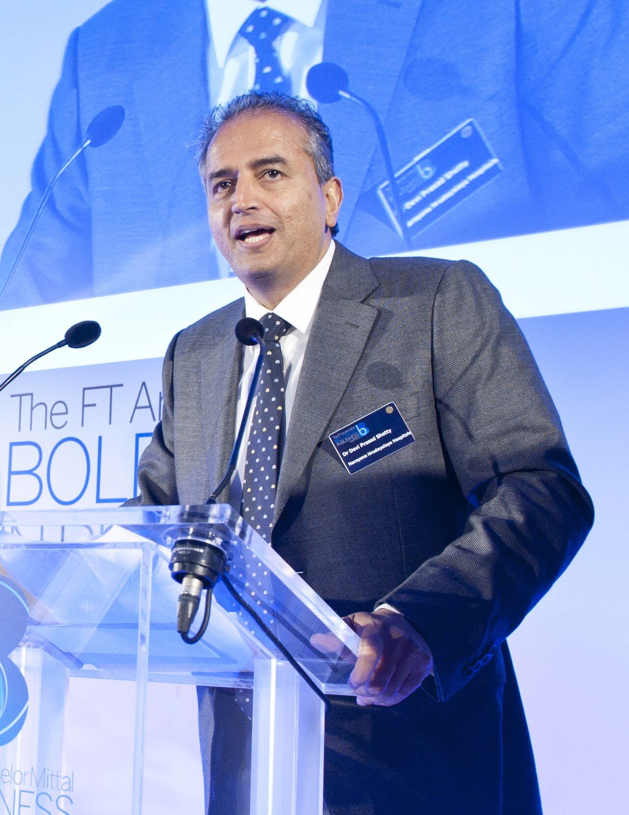 Devi Shetty speaking at a lectern.